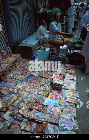 Outdoor-Magazinverkäuferin mit Zeitschriften auf Asphalt, Alt-Delhi, Neu-Delhi, Indien Stockfoto