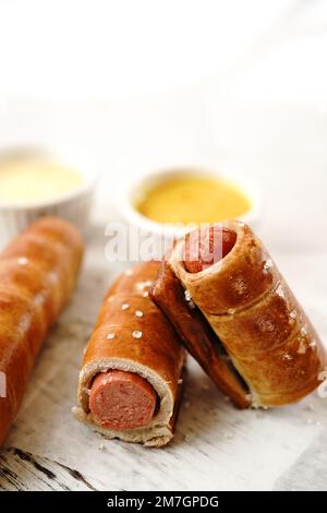 Brezel Hot Dogs serviert mit Sauce, selektiver Fokus - Snacks am Spieltag Stockfoto