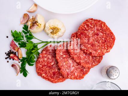 Kochzutaten, rohe Burgerschnitzel an Bord Stockfoto
