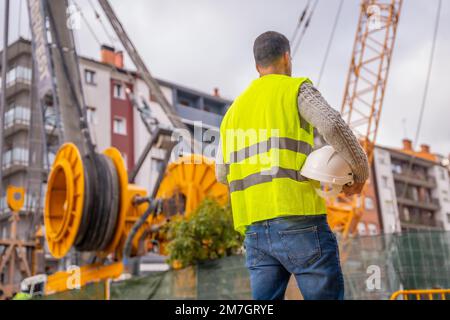 Bauleiter und technischer Ingenieur beobachten den Bau der Stadt, beobachten die Ausrüstung und den Kran Stockfoto