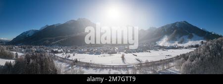 Panoramablick auf die Skistadt Kranjska Gora in Slowenien, die an einem kalten, sonnigen Wintermorgen mit Schnee bedeckt ist. Stockfoto