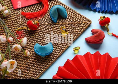 Matte mit Glückskeksen, Sakura und chinesischen Symbolen auf blauem Hintergrund. Neujahrsfeier Stockfoto
