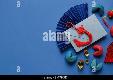 Glückskekse mit Umschlag und chinesischen Symbolen auf blauem Hintergrund. Neujahrsfeier Stockfoto