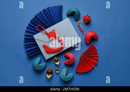 Glückskekse mit Umschlag und chinesischen Symbolen auf blauem Hintergrund. Neujahrsfeier Stockfoto