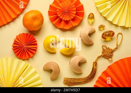 Glückskekse mit Mandarin und chinesischen Symbolen auf gelbem Hintergrund. Neujahrsfeier Stockfoto