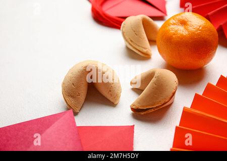 Glückskekse mit Mandarin auf weißem Hintergrund, Nahaufnahme. Chinesische Neujahrsfeier Stockfoto