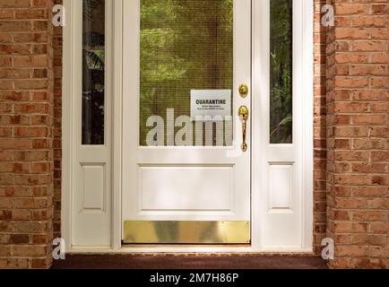 Coronavirus-Pandemie-Mitteilung. Mann hängt Covid-19 Virus Selbstquarantäne-Schild im Fenster der Haustür. Quarantänewarnung für Wohnungseingang. Stockfoto