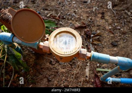 Wasserzähler auf Wasserleitung pvc auf dem Boden, alter Wasserzähler zur Überprüfung der Schätzung des Wasserverbrauchs im Dorf Stockfoto