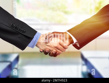 Nahaufnahme von zwei Geschäftsleuten, die sich in einem Büro die Hand schütteln Stockfoto