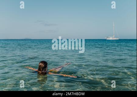 Eine unbekannte Frau, die im Meer schwimmt Stockfoto