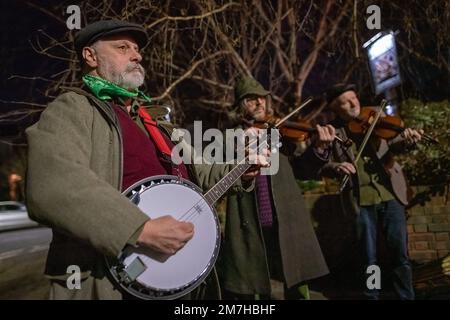 London, Großbritannien. 9. Januar 2023. Plough-Montag-Feiern. Das Folk-Tanz-Ensemble „Fowlers Molly Dancers“ tritt in Deptford und Greenwich auf und tanzt in der abendlichen Straßenbeleuchtung vor lokalen Pubs. Am ersten Montag nach der zwölften Nacht oder Epiphany ist der Plough Monday der bedeutendste Tag im Kalender der alten Herrlichkeit. Es geht bis ins späte 15. Jahrhundert zurück und ist historisch gesehen der Tag, der das Ende der Weihnachtszeit und die Rückkehr zur Arbeit für die landwirtschaftlichen Gemeinden in den östlichen Grafschaften Englands kennzeichnete. Kredit: Guy Corbishley/Alamy Live News Stockfoto