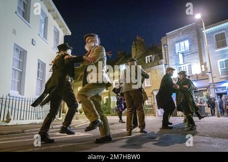 London, Großbritannien. 9. Januar 2023. Plough-Montag-Feiern. Das Folk-Tanz-Ensemble „Fowlers Molly Dancers“ tritt in Deptford und Greenwich auf und tanzt in der abendlichen Straßenbeleuchtung vor lokalen Pubs. Am ersten Montag nach der zwölften Nacht oder Epiphany ist der Plough Monday der bedeutendste Tag im Kalender der alten Herrlichkeit. Es geht bis ins späte 15. Jahrhundert zurück und ist historisch gesehen der Tag, der das Ende der Weihnachtszeit und die Rückkehr zur Arbeit für die landwirtschaftlichen Gemeinden in den östlichen Grafschaften Englands kennzeichnete. Kredit: Guy Corbishley/Alamy Live News Stockfoto