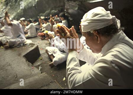 Ein balinesischer Clan betet während eines Rituals zusammen, um die Geister ihrer verstorbenen Familienmitglieder zu ehren und zu reinigen, in einem Tempel in der Besakih-Tempelanlage am Hang des Agung in Karangasem, Bali, Indonesien. Stockfoto