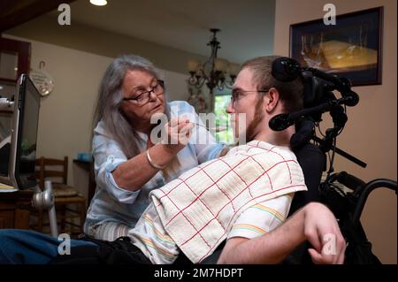 Valle Crusis, North Carolina, USA. 13. Okt. 2022. Nita Wilcox füttert ihren Sohn Luke Apfelmus für seinen Mittagssnack. Luke, der eine Zerebralparese hat und Querschnittsgelähmt ist, kann sich nicht selbst ernähren. (Kreditbild: © Robin Rayne/ZUMA Press Wire) NUR REDAKTIONELLE VERWENDUNG! Nicht für den kommerziellen GEBRAUCH! Stockfoto