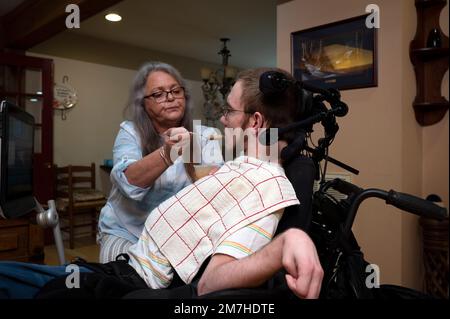 Valle Crusis, North Carolina, USA. 13. Okt. 2022. Nita Wilcox füttert ihren Sohn Luke Apfelmus für seinen Mittagssnack. Luke, der eine Zerebralparese hat und Querschnittsgelähmt ist, kann sich nicht selbst ernähren. (Kreditbild: © Robin Rayne/ZUMA Press Wire) NUR REDAKTIONELLE VERWENDUNG! Nicht für den kommerziellen GEBRAUCH! Stockfoto