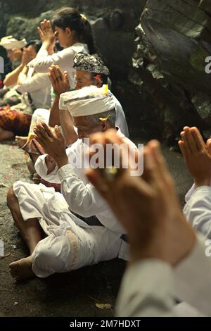 Ein balinesischer Clan betet während eines Rituals zusammen, um die Geister ihrer verstorbenen Familienmitglieder zu ehren und zu reinigen, in einem Tempel in der Besakih-Tempelanlage am Hang des Agung in Karangasem, Bali, Indonesien. Stockfoto