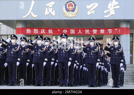 YANTAI, CHINA - 10. JANUAR 2023 - Polizeibeamte salutieren der Polizeiflagge in der Gaoxin-Abteilung des Büros für öffentliche Sicherheit in Yantai, Ostchina S. Stockfoto