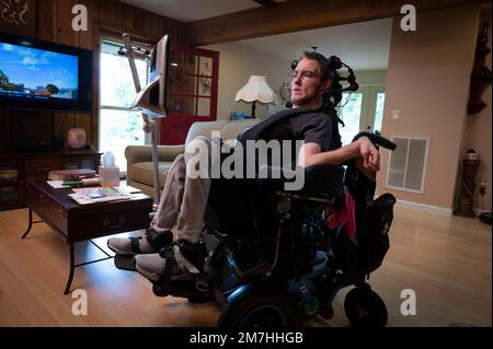 Valle Crusis, North Carolina, USA. 12. September 2022. Luke Wilcox, 22, sitzt im Rollstuhl im Landhaus seiner Eltern, um fernzusehen und auf seinem speziellen Computer zu tippen, der seinen Augenblick erkennt, um seine Nachrichten zu tippen. (Kreditbild: © Robin Rayne/ZUMA Press Wire) NUR REDAKTIONELLE VERWENDUNG! Nicht für den kommerziellen GEBRAUCH! Stockfoto