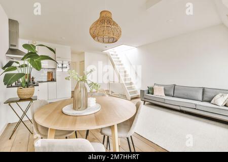 Ein Wohnzimmer mit einer Couch, Tisch und Treppen, die in die oberste Etage in einem Dachgeschoss-Haus führen Stockfoto