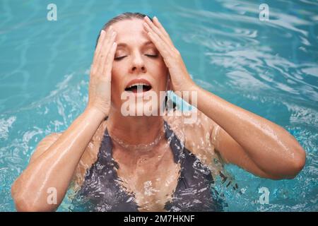 Das war erfrischend. Ein reifer, der aus dem Wasser in einem Schwimmbad auftaucht. Stockfoto