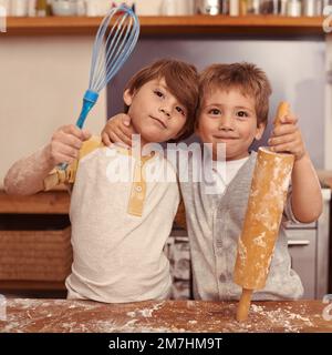 Das stimmt, es waren die besten Bäcker aller Zeiten. Zwei junge Brüder, die in der Küche backen. Stockfoto