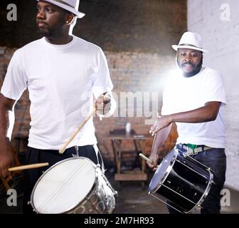 Er spielt mit dem brasilianischen Beat. Eine Band spielt ihre Schlaginstrumente in brasilianischem Setting. Stockfoto