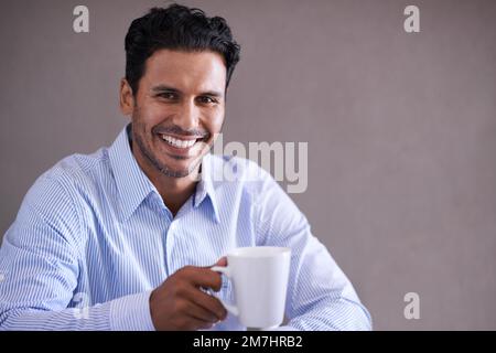 Ich mache eine Kaffeepause. Ein gutaussehender junger Geschäftsmann in einer Kaffeepause. Stockfoto