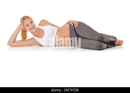 Nach ihrem Workout eine Pause einlegen. Studioporträt einer jungen Frau in Sportkleidung, die auf der Seite liegt. Stockfoto