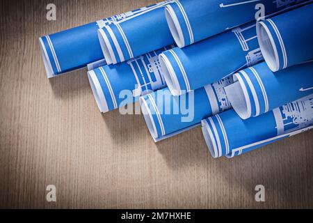 Zur Zusammensetzung blauer Blueprint-Rollen auf Holzbrettbaukonzepten. Stockfoto