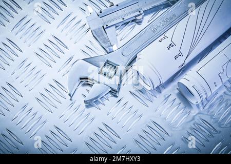 Konstruktionszeichnungen Rollgabelschlüssel mit Trammelzange auf gerillten Metallplatten Wartungskonzept. Stockfoto