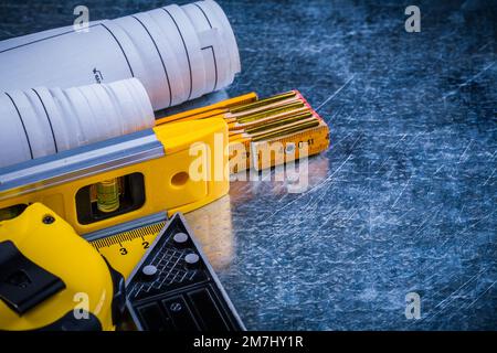 Baustellenpläne und Messwerkzeuge auf metallisch zerkratzten Oberflächen und Architekturkonzept. Stockfoto