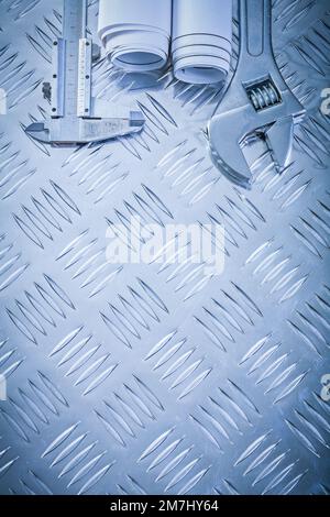 Baupläne Einstellschlüssel für Trammelzangen auf gerillten Metallplatten Wartungskonzept. Stockfoto