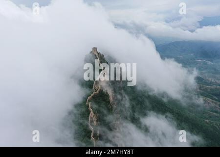 Peking, China. 4. Juli 2022. Dieses Luftfoto wurde am 4. Juli 2022 aufgenommen und zeigt Wolken, die über der Chinesischen Mauer an der Grenze zwischen Luanping County in Nordchina der Provinz Hebei und Miyun District von Peking, Hauptstadt von China, schweben. Kredit: Chen Yehua/Xinhua/Alamy Live News Stockfoto