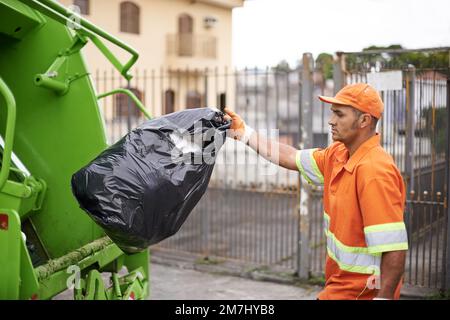 Jemand muss es tun. Ein beschäftigter Müllsammler. Stockfoto