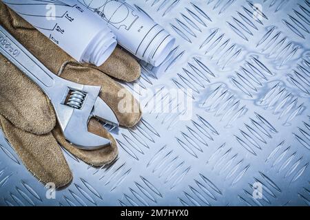 Lederschutzhandschuhe Konstruktionszeichnungen verstellbarer Schraubenschlüssel auf gerilltem Metallblech Baukonzept. Stockfoto