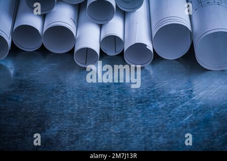 Rollen weißer Blaupausen auf zerkratztem metallischem Hintergrund und Architekturkonzept. Stockfoto