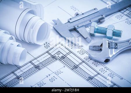 Schraubbolzen mit Mutter Einstellbarer Schraubenschlüssel Sattelrollen von Bauplänen auf Bauplan-Architektur und Baukonzept. Stockfoto