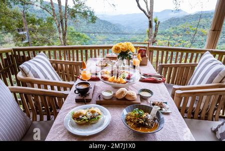 Top-Blick auf ein luxuriöses Frühstück in den Bergen von Chiang Mai Thailand, Luxusfrühstück mit Chiang Mai Curry Nudelsuppe oder Khao Soi Gai und Obst und Kaffee auf dem Tisch. Stockfoto