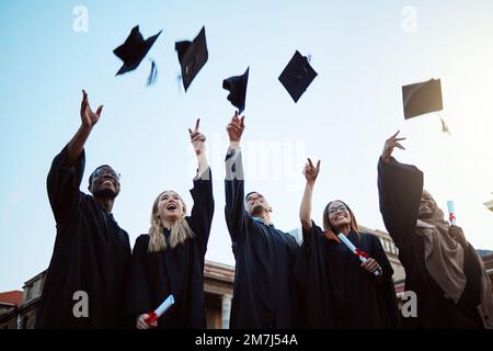 Abschlussfeier, Ausbildung und Erfolg mit Freunden bei der Feier als Graduiertengruppe im Freien mit Mörtelkappen. Diversität, Universität und Mensch und Stockfoto