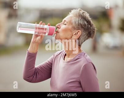 Fitness, Läufer oder Seniorin, die Wasser trinkt und Sportziele in der Pause ausübt oder sich entspannt. Gesunde, müde oder durstige ältere Dame trinkt natürlich Stockfoto