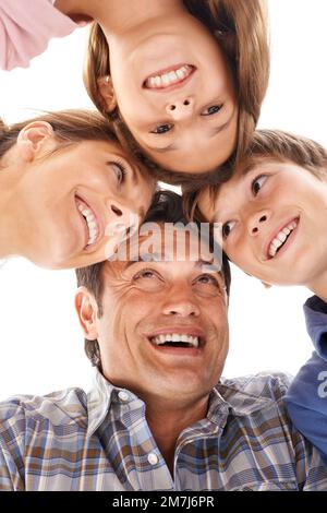 Du schaust auf eine Familie, die weiß, wie man Viel Spaß. macht Ein kleiner Winkel von einer glücklichen vierköpfigen Familie, die in einem Meeting steht. Stockfoto