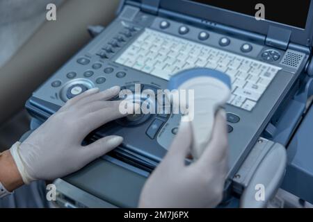 Nahaufnahme der Arzthand am Ultraschallgerät Stockfoto