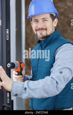 Porträt einer stattlichen Handwerker mit Bohrer Stockfoto