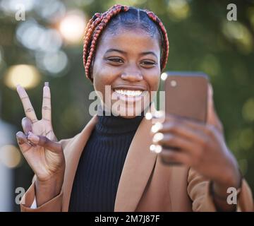 Gesicht, Telefon Selfie und schwarze Frau mit Friedensschild im Park Outdoor. Technologie, Mobiltelefon und Frau mit Handgesten, die ein Bild oder Foto macht Stockfoto
