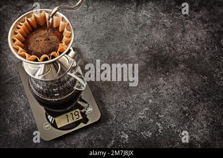 Alternative Kaffeezubereitung. Tropfendes Wasser Aus Dem Gooseneck-Wasserkocher In Den Filterhalter Der Kaffeetrockner Mit Gemahlenem Kaffee. Tassenteller, Kaffeekocher Stan Stockfoto