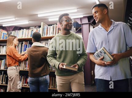 Bildung, Schüler oder Freunde in der Bibliothek an einer Universität, einer Hochschule oder Schule lernen, reden oder studieren. Studium, Stipendium oder junge Männer Stockfoto