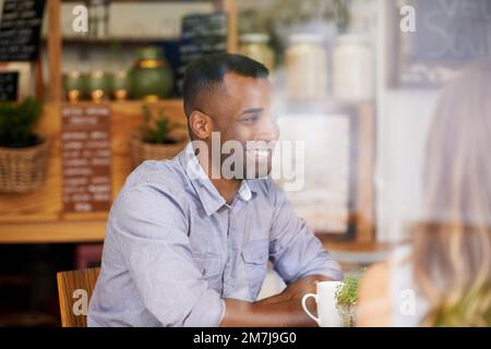 Ich bin so froh, dass wir uns treffen konnten. Ein junger Mann, der mit seiner Freundin Kaffee trinkt. Stockfoto