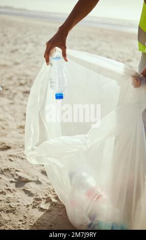 Reinigung, Plastik und Hände von Freiwilligen am Strand für Recycling, Umwelt oder Erdtag. Recycling, Nachhaltigkeit und Klimawandel mit Wohltätigkeitsorganisation Stockfoto