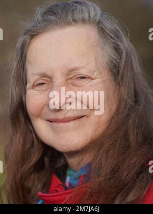 Freundliche 63-jährige Frau ohne Make-up schaut in die Kamera Stockfoto