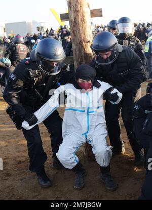Erkelenz, Deutschland. 10. Januar 2023. Ein Klimaschutzaktivist wird von der Polizei in Lützerath mitgerissen. Lützerath soll für die Erweiterung des Braunkohlebergwerks Garzweiler II abgebaut werden. Kredit: Oliver Berg/dpa/Alamy Live News Stockfoto